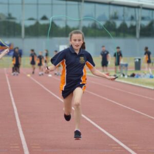 girl skipping down an athletics track