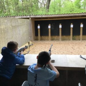 boys lining up guns to shoot targets
