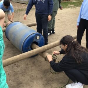 girl wrapping up a raft with a piece of string