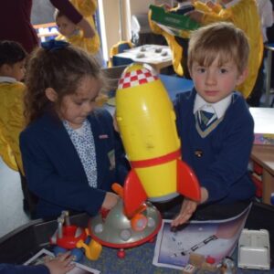 2 students holding a yellow rocket