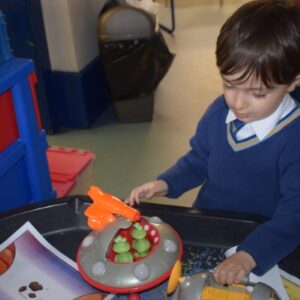 young boy playing with space toys