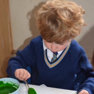 child putting icing on top of a biscuit