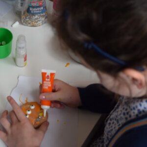 child adding icing to a biscuit