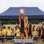 Student with trophy in the air