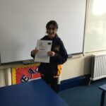 student holding up a presentation sheet