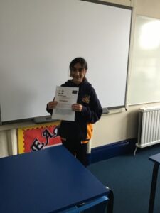 student holding up a presentation sheet