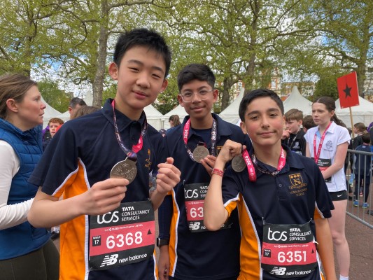 students holding their medals after a marathon