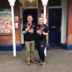 mand and woman holding their medals