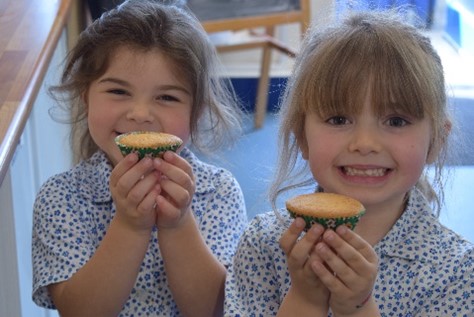 students holding tea cakes